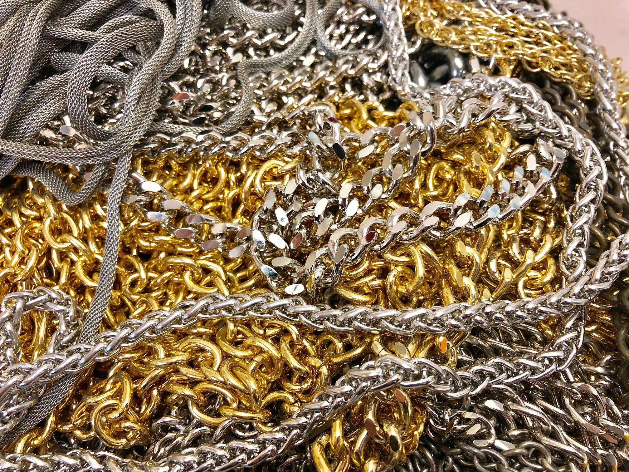Foto di numerose catene d'oro e d'argento e fili metallici in un groviglio